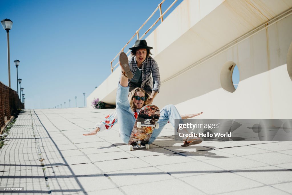 Young woman falling off skateboard