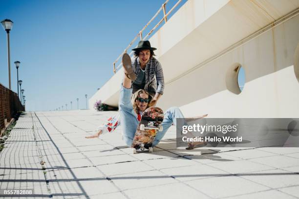 young woman falling off skateboard - world laughter day stock pictures, royalty-free photos & images