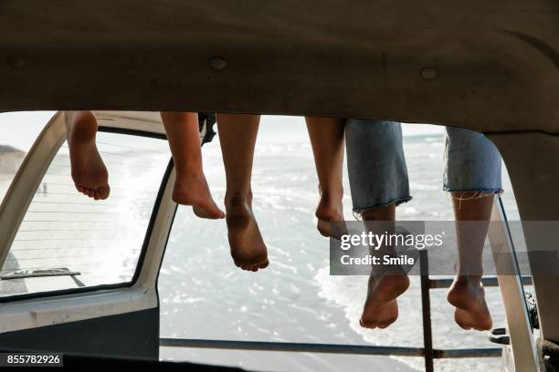 legs hanging from roof of car - friends smile bildbanksfoton och bilder