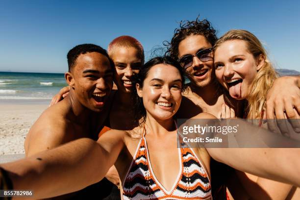 friends taking a selfie of themselves on the beach - beach friends stock-fotos und bilder