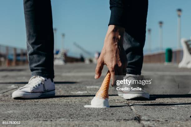 man reaching for a dropped ice-cream on the boardwalk - clumsy stock pictures, royalty-free photos & images