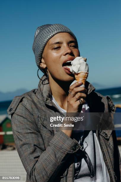 young woman licking an ice-cream - lamber imagens e fotografias de stock