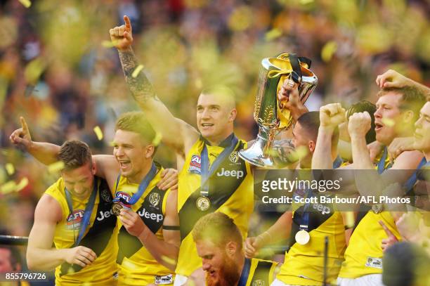 Dustin Martin of the Tigers celebrates with the AFL Premiership Cup on stage as confetti flies in the air after winning the 2017 Toyota AFL Grand...