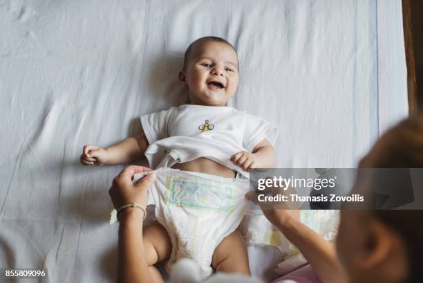 mother with her newborn son - changing nappy stock pictures, royalty-free photos & images