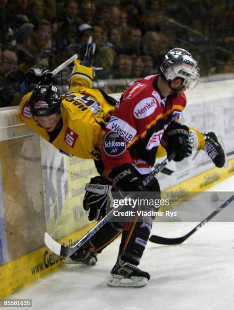 Chris Harrington of Metro Stars body checks Patrick Hager of Pinguine during the DEL sixth quarter final play-off game between Krefeld Pinguine and...