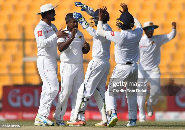 Rangana Herath of Sri Lanka celebrates with his team taking the wicket of Asad Shafiq of Pakistan during Day Three of the First Test between Pakistan...