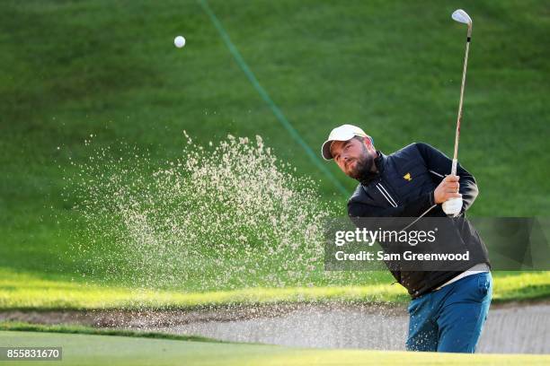 Marc Leishman of Australia and the International Team plays a shot from a bunker on the third hole during Saturday foursome matches of the Presidents...
