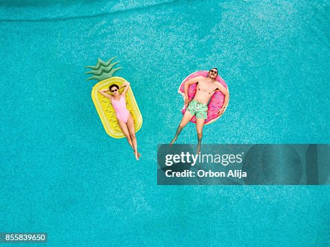 Couple relaxing at swimming pool Couple relaxing at swimming pool