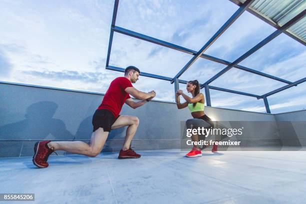 sportieve vrouw doen warming-up squat met fitness instrutor - instrutor stockfoto's en -beelden