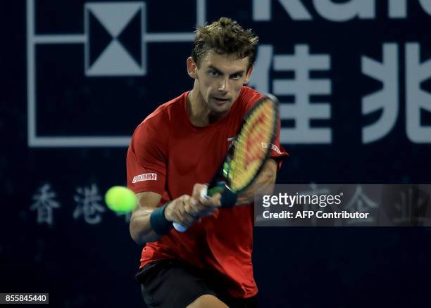 Henri Laaksonen of Switzerland hits a return against David Goffin of Belgium during their men's singles semi-final match at the ATP Shenzhen Open...