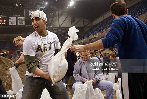 Abdullelah Alshamrani of Saudi Arabia and Ali Aluattan of Kuwait stack newly-filled sandbags during a sandbagging operation at the Fargo Dome March...
