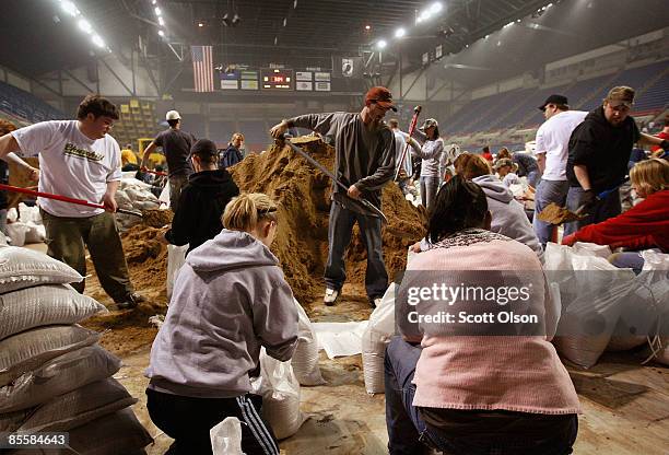 Volunteers fill sandbags during a sandbagging operation at the Fargo Dome March 24, 2009 in Fargo, North Dakota. The city has launched a massive...