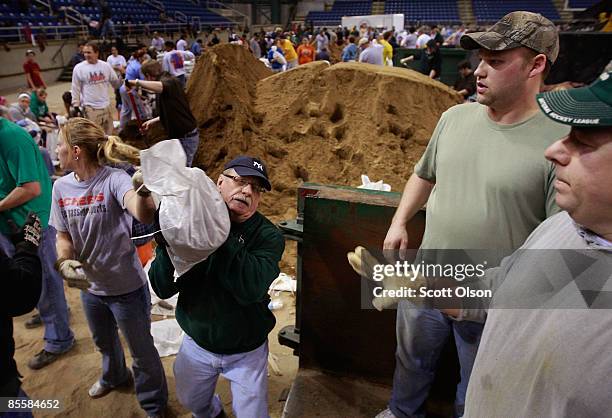 Volunteers fill sandbags during a sandbagging operation at the Fargo Dome March 24, 2009 in Fargo, North Dakota. The city has launched a massive...