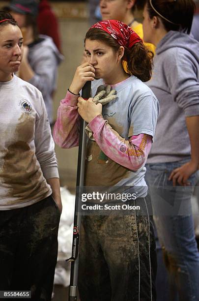 Alexa Westbee, a student from Concordia College, takes a break from filling sandbags during a sandbagging operation at the Fargo Dome March 24, 2009...