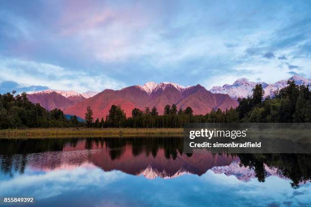 avondlicht op lake matheson in nieuw-zeeland - mt cook range stockfoto's en -beelden