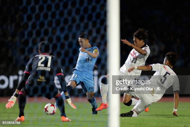 Yu Kobayashi of Kawasaki Frontale shoots at the goal while Tatsuya Yamashita and Yusuke Tanaka of Cerezo Osaka try to block during the J.League J1...