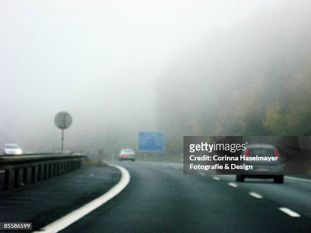 foggy day on a highway - corinna haselmayer stockfoto's en -beelden
