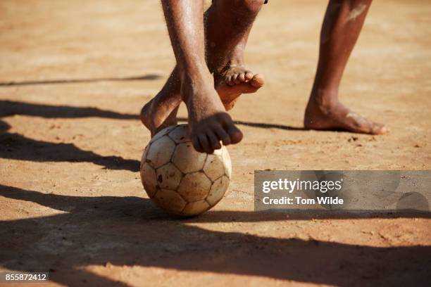 close up shot of 2 pairs bare feet playing football - barefeet soccer stock pictures, royalty-free photos & images