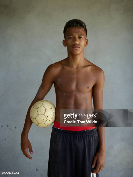 portrait of young brazilian man holding a football - the project portraits stock pictures, royalty-free photos & images