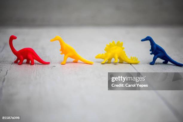 colorful dinosaurs in a row - tyrannosaur stock pictures, royalty-free photos & images