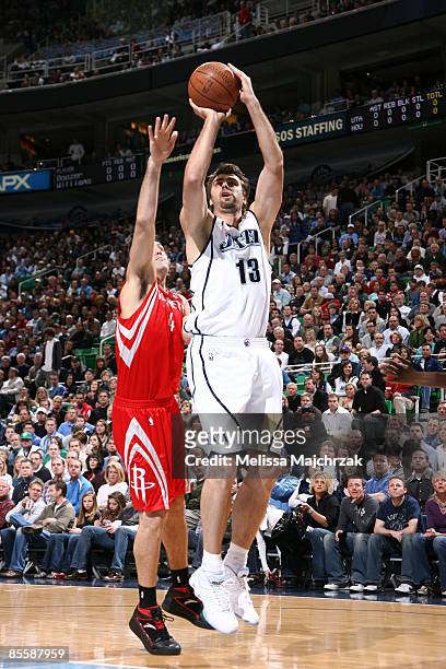 Mehmet Okur of the Utah Jazz goes for the shot as Luis Scola of the Houston Rockets tries to block at EnergySolutions Arena on March 24, 2009 in Salt...