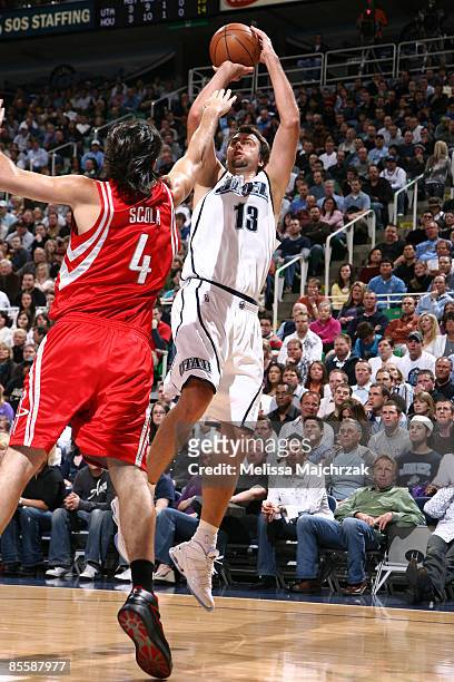 Mehmet Okur of the Utah Jazz goes for the shot as Luis Scola of the Houston Rockets tries to block at EnergySolutions Arena on March 24, 2009 in Salt...