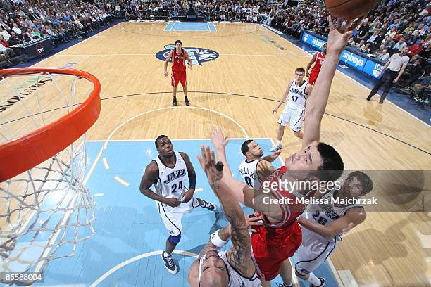 Yao Ming of the Houston Rockets goes for the shot as Carlos Boozer of the Utah Jazz tries to block at EnergySolutions Arena on March 24, 2009 in Salt...