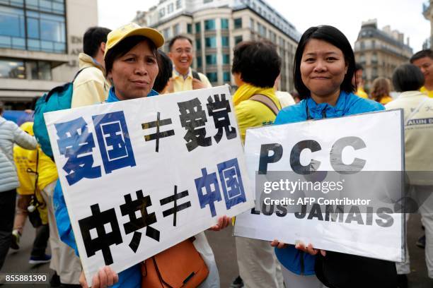 Women hold a placard reading "CPC never again" demonstrate to support the practice of Falun Dafa in China , in Paris on September 30, 2017. China's...