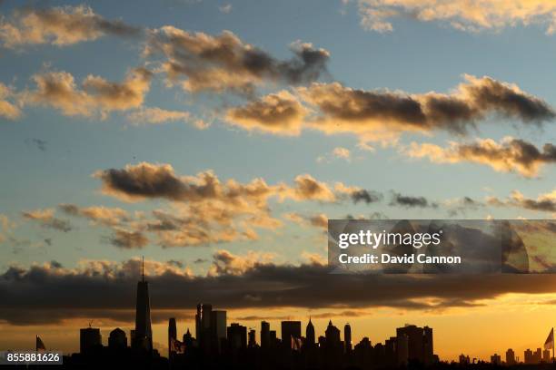 The sun rises behind the Manhattan skyline during the Saturday morning foursomes matches in the 2017 Presidents Cup at the Liberty National Golf Club...