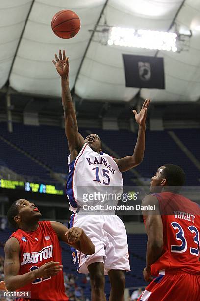 Tyshawn Taylor of the Kansas Jayhawks drives for a shot attempt in the first half against Paul Wlliams and Chris Wright of the Dayton Flyers during...
