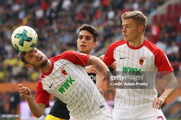Marcel Heller of Augsburg, Christian Pulisic of Dortmund and Alfred Finnbogason of Augsburg during the Bundesliga match between FC Augsburg and...