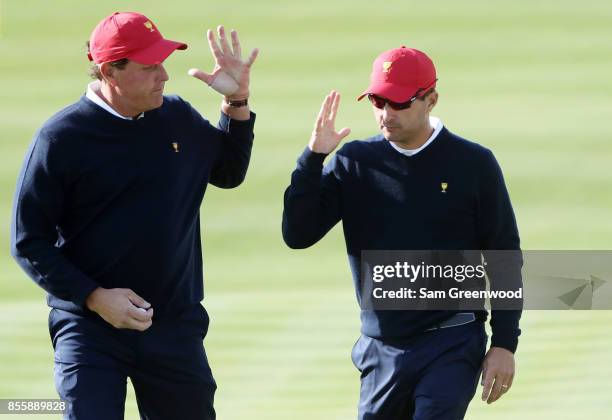 Phil Mickelson and Kevin Kisner of the U.S. Team react on the eighth green after winning the hole against Emiliano Grillo of Argentina and the...