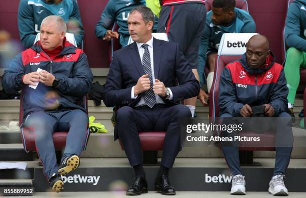 Swansea City Assistant manager Nigel Gibbs, Swansea manager Paul Clement and Swansea assistant coach Claude Makelele sit on the bench during the...