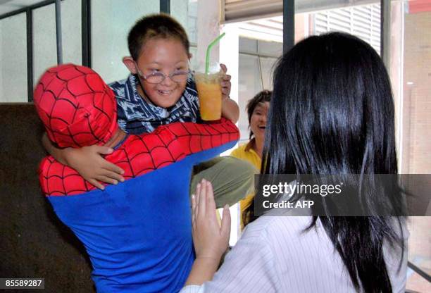 This photo taken on March 23, 2009 shows a Thai fireman dressed in a Spider-Man costume carrying a boy at a special needs school in Bangkok. The Thai...