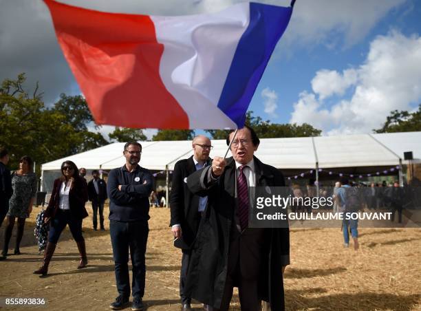 French right-wing Les Republicains party member waves the national flag at the "Fete de la Violette" , a political gathering organised by Guillaume...