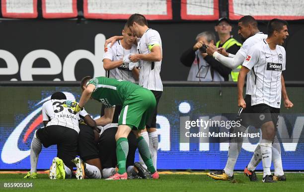 Sebastien Haller of Frankfurt is celebrated by team mates after he scored the late winning goal to make it 2:1 during the Bundesliga match between...