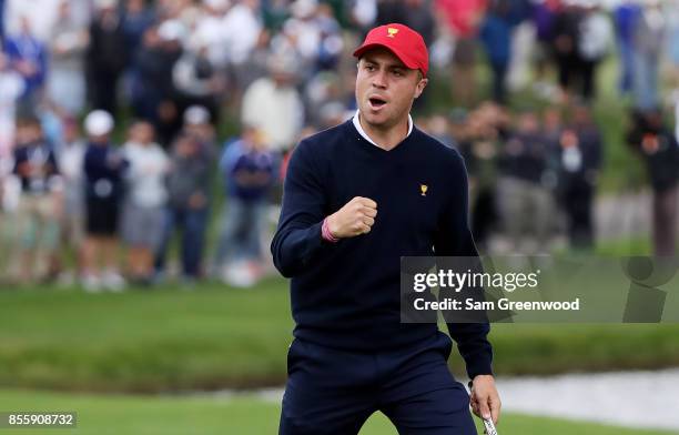 Justin Thomas reacts on the 18th green as he and Rickie Fowler of the U.S. Team go halves with Branden Grace of South Africa and the International...