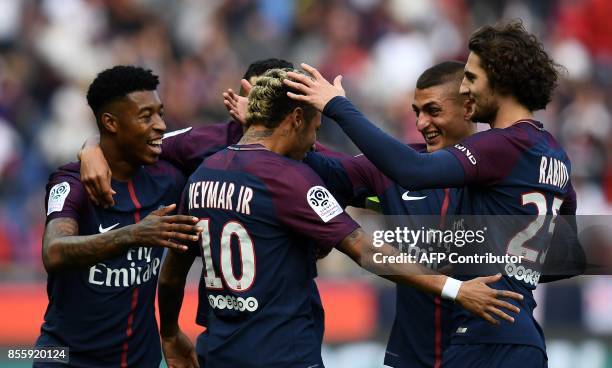 Paris Saint-Germain's Brazilian forward Neymar is congratuled by teammates after scoring a goal during the French L1 football match between Paris...