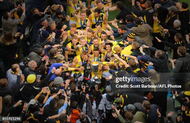 Trent Cotchin of the Tigers, Dustin Martin of the Tigers celebrate with the the AFL Premiership Cup and supporters in the crowd as the Tigers make...