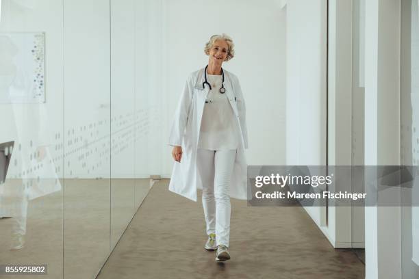 female doctor wearing a surgical mask - doctors walking stock-fotos und bilder