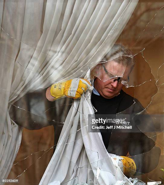 Glazier prepares to remove a smashed window at the Edinburgh home of former Royal Bank of Scotland boss Sir Fred Goodwin after it was attack by...