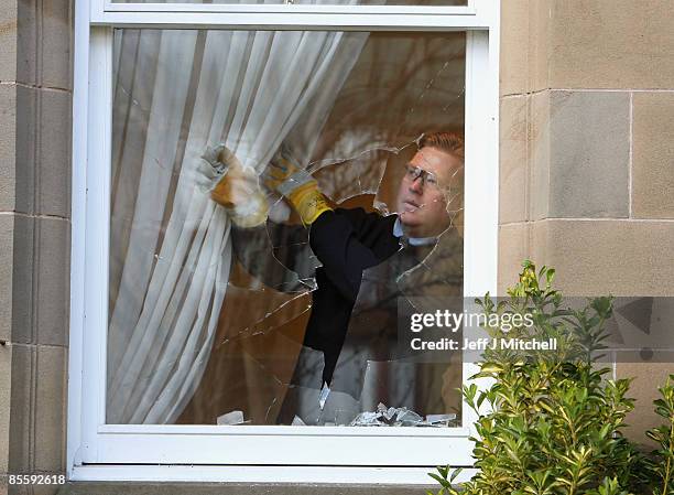 Glazier prepares to remove a smashed window at the Edinburgh home of former Royal Bank of Scotland boss Sir Fred Goodwin after it was attack by...