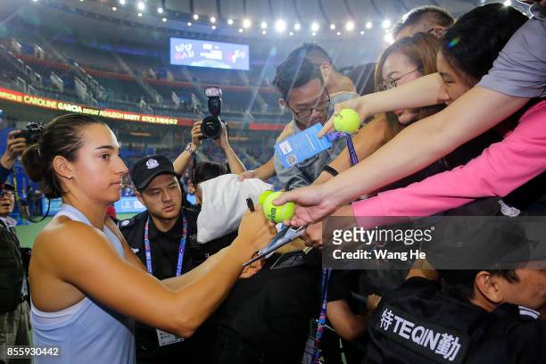 Caroline Garcia of France autographs for fans after defeating Ashleigh Barty of Australia in the Finals match of Women's Single of 2017 Wuhan Open on...
