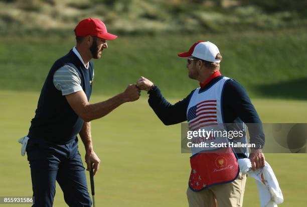Dustin Johnson of the U.S. Team reacts to his putt with caddie John Wood during the Saturday morning foursomes matches during the third round of the...