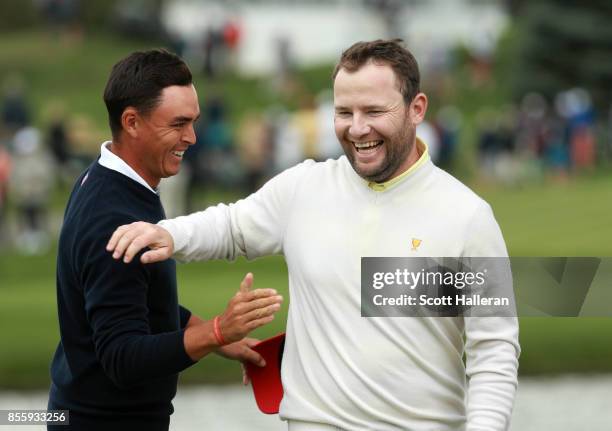 Rickie Fowler of the U.S. Team and Branden Grace of South Africa and the International Team shake hands after their round during the Saturday morning...