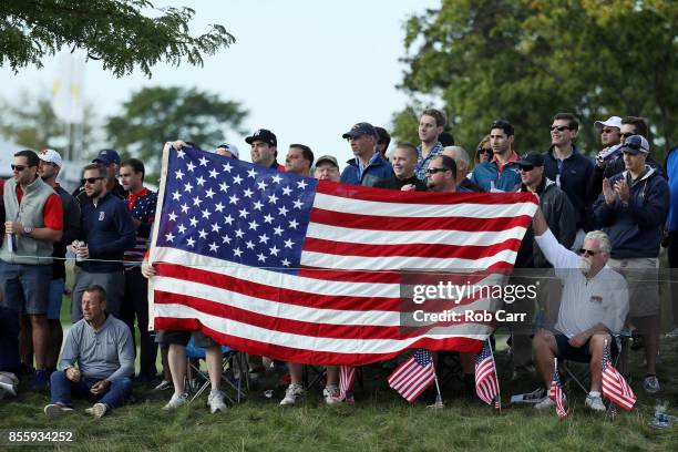 Fans hold up a United States flag during Saturday foursome matches of the Presidents Cup at Liberty National Golf Club on September 30, 2017 in...