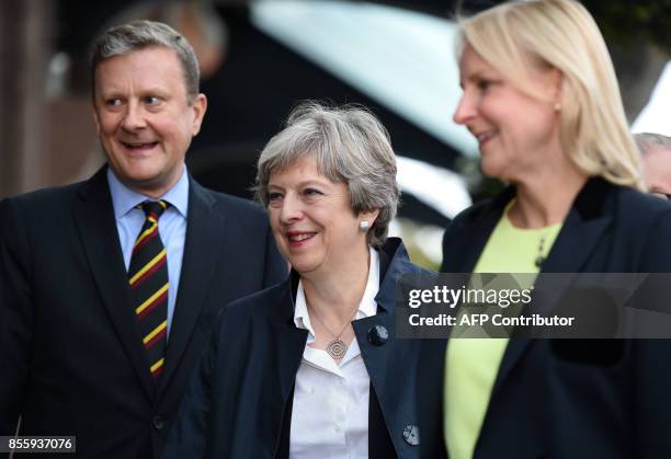 Britain's Prime Minister Theresa May is flanked by the president of the National Conservative Convention, Andrew Sharpe and his wife on her arrival...