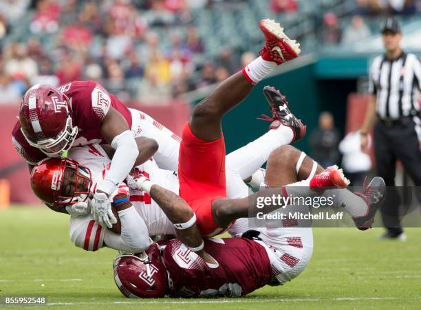 Sean Chandler and Shaun Bradley of the Temple Owls tackle Linell Bonner of the Houston Cougars in the first quarter at Lincoln Financial Field on...