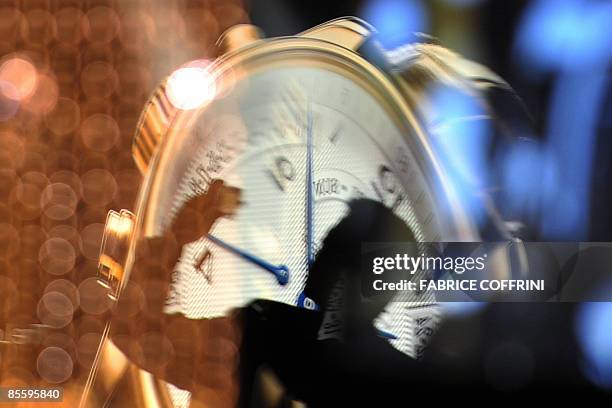 This photo shows the reflection of a visitor as he snaps a picture at the Longines booth on the press day at the Baselworld 2009 watch and jewellery...