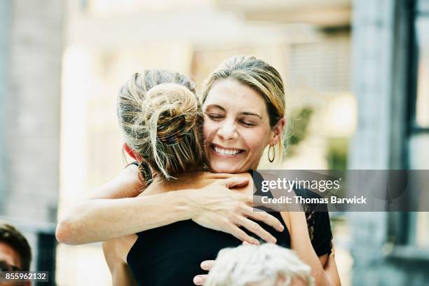 two friends embracing before dinner party on summer evening - boa notícia imagens e fotografias de stock